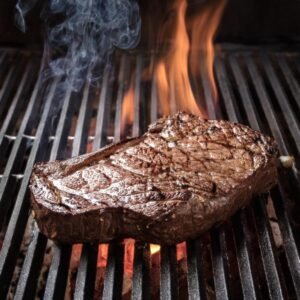 Chuck eye steak sizzling on a grill