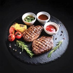 Grilled chuck eye and ribeye steaks on a serving platter