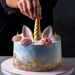 A step-by-step image of a Unicorn Cake being decorated with frosting and fondant details.