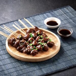 Japanese yakitori skewers of chicken hearts glazed with tare sauce, served with green onions