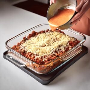 Layering tortillas and filling in a baking dish for Mexican lasagna