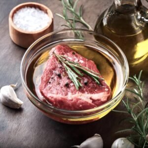 Raw chuck eye steak being marinated