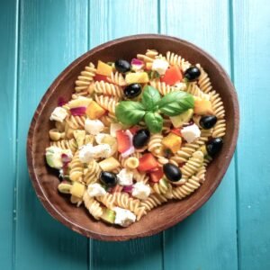 A Mediterranean pasta salad and a Hawaiian macaroni salad served in decorative bowls with garnishes