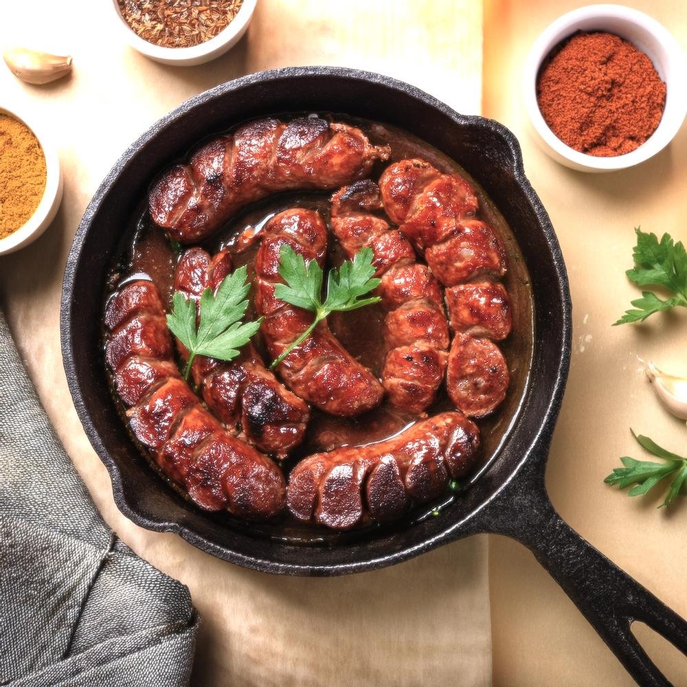 A skillet of cooked beef chorizo with fresh herbs