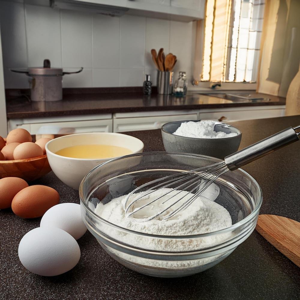 Heavy cream, eggs, and flour arranged on a kitchen countertop.Pancakes with Cream in the Batter