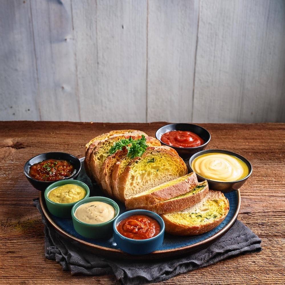 Sliced garbage bread served with marinara and ranch dips.