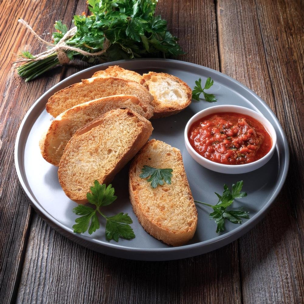 Sliced garbage bread served on a plate with marinara dipping sauce.