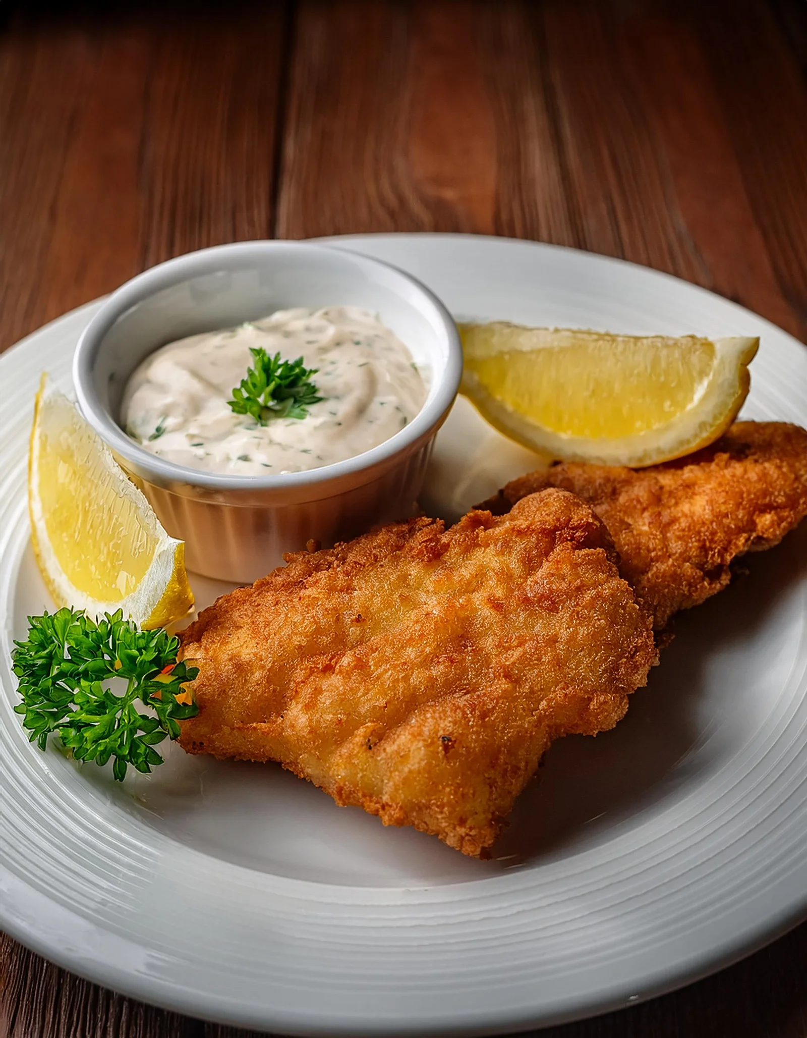 https://grantrecipes.com/wp-content/uploads/2025/02/Firefly-A-close-up-of-crispy-fried-fish-on-a-white-plate-served-with-lemon-wedges-tartar-sauce-an