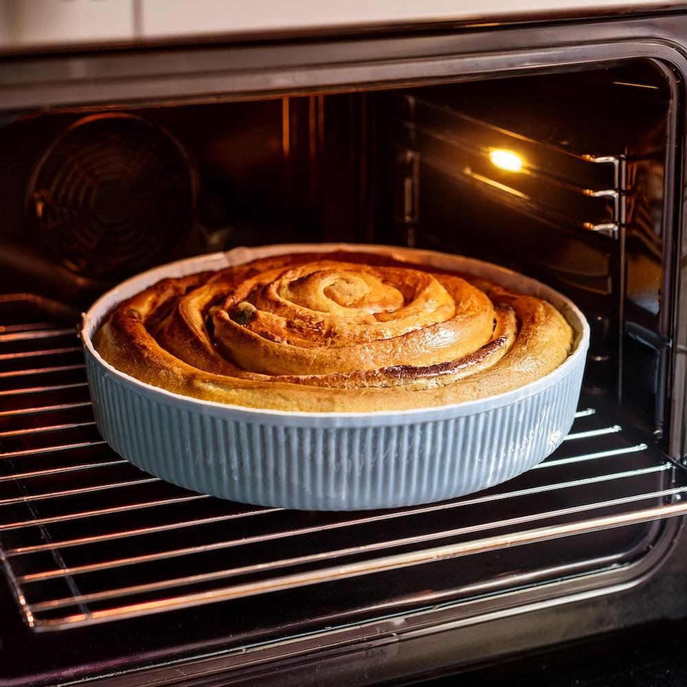 A freshly baked cinnamon bun cheesecake cooling in the oven