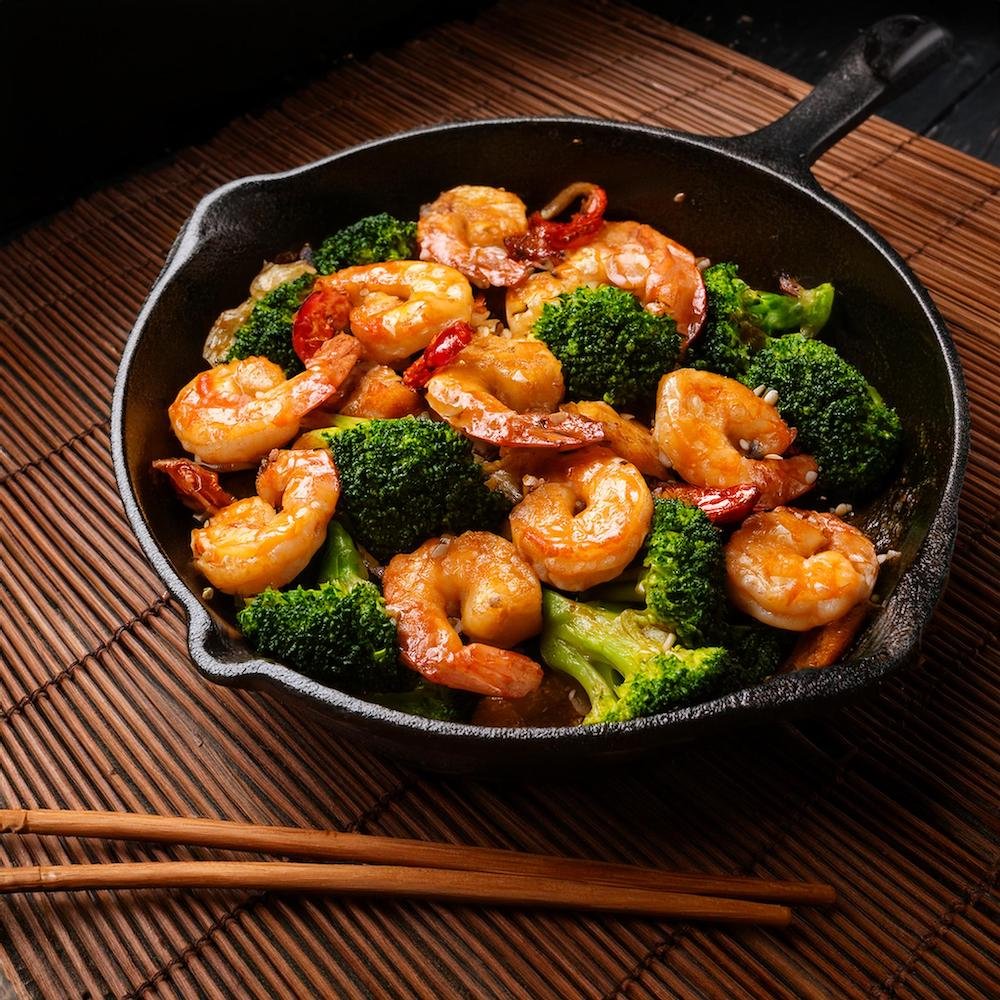 Honey garlic shrimp sausage and broccoli in a skillet with sesame seeds