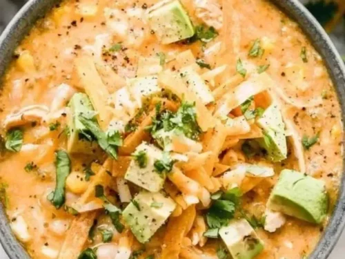 A bowl of award winning white chicken chili garnished with cilantro and jalapeños.