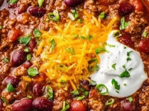 Bowl of delicious ground beef stovetop chili garnished with fresh herbs.