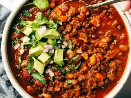Bowl of the best Sunday chili topped with cheese and herbs