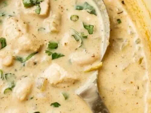 Bowl of best white chili topped with cilantro and served with cornbread