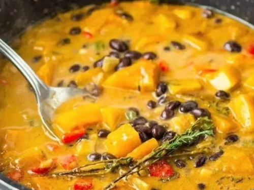 Hearty black bean stew with butternut squash and collard greens served in a bowl