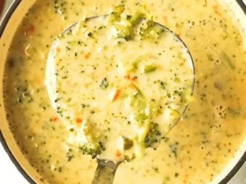 Bowl of creamy Broccoli Cheddar Soup garnished with fresh broccoli florets.