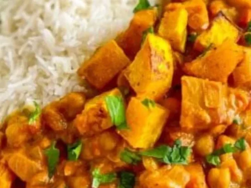 A vibrant bowl of butternut squash and chickpea curry with spices.