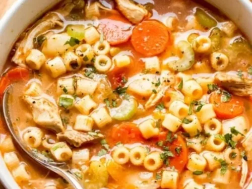 Bowl of delicious homemade chicken soup garnished with herbs