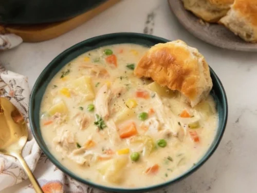 Delicious chicken pot pie soup served in a bowl with herbs on top