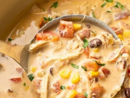 Bowl of creamy chicken taco soup garnished with cilantro and lime.