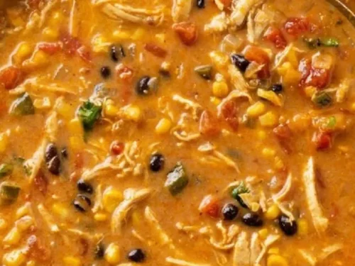 Creamy chicken tortilla soup garnished with tortilla strips and avocado