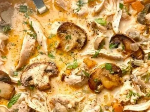 Creamy chicken wild rice soup in a rustic bowl, garnished with herbs.