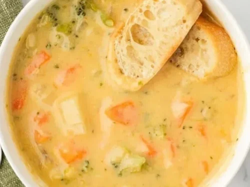 Bowl of creamy vegetable soup garnished with fresh herbs and vegetables