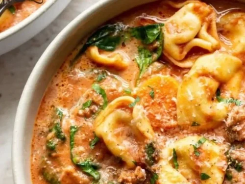 Crockpot Tortellini Soup garnished with herbs and served in a bowl