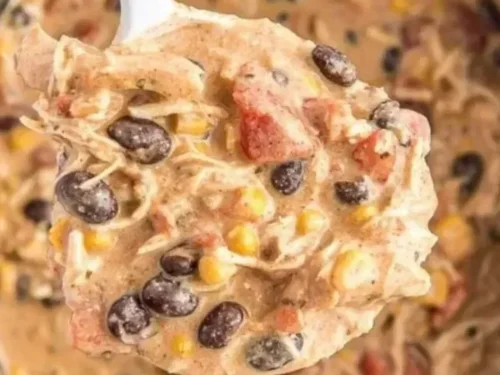 Delicious bowl of crockpot white chicken chili topped with cilantro and cheese.