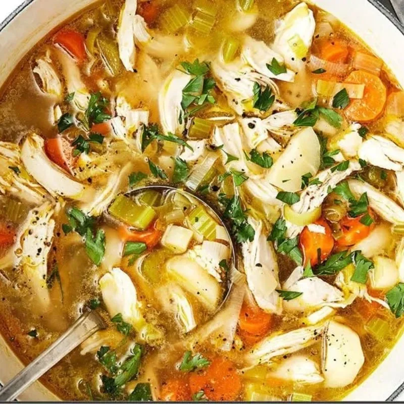 Bowl of homemade chicken soup with vegetables and herbs