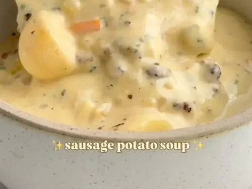 Bowl of homemade sausage potato soup garnished with herbs