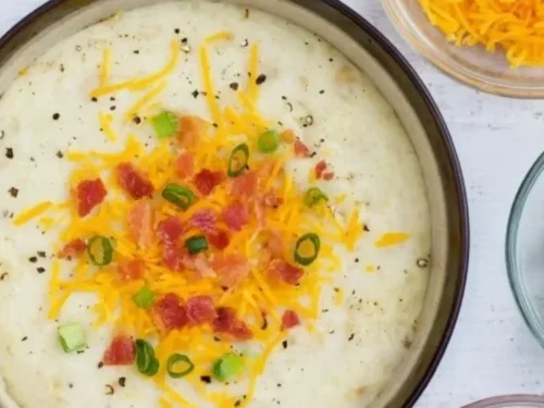 Bowl of loaded baked potato soup topped with cheese, bacon, and green onions