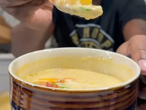 Bowl of loaded potato soup topped with cheese, bacon, and chives