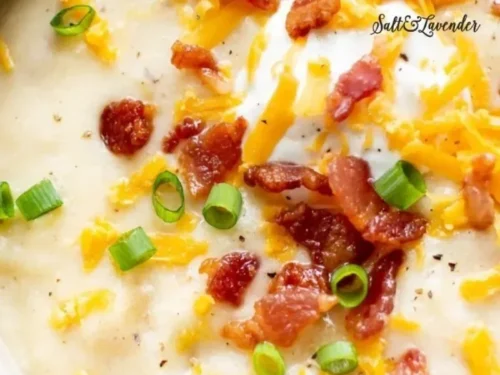 Creamy loaded potato soup topped with cheese, bacon, and chives in a bowl