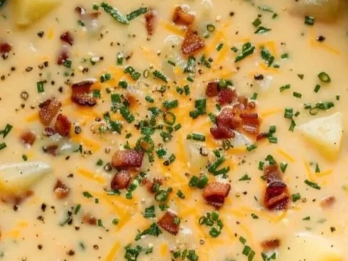Bowl of creamy Loaded Potato Soup topped with cheese, bacon, and green onions