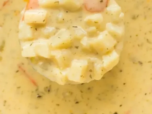 A steaming bowl of homemade Potato Vegetable Soup garnished with herbs