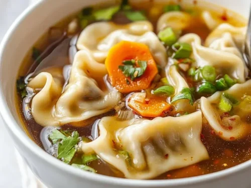 A bowl of delicious Potsticker Soup garnished with green onions and cilantro