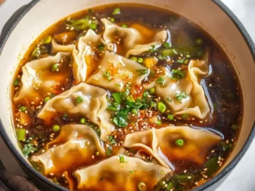 Bowl of delicious potsticker soup with dumplings and vegetables.