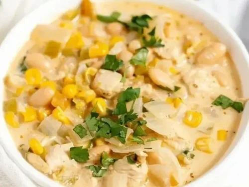 Bowl of white bean chicken chili topped with cilantro and lime wedges