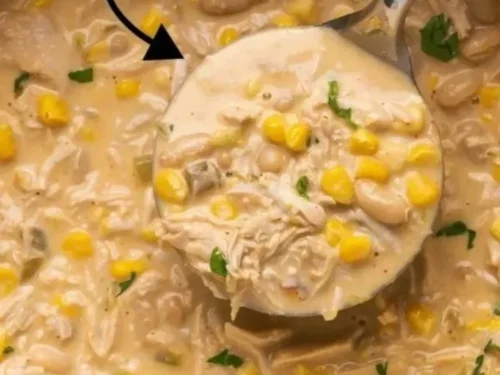 A bowl of creamy white chicken chili garnished with cilantro and lime.