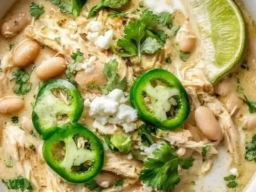 Delicious bowl of white chicken chili garnished with cilantro and lime
