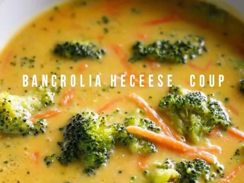 Bowl of creamy broccoli cheddar soup topped with cheese and herbs