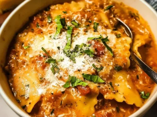 Bowl of creamy lasagna soup topped with cheese and herbs