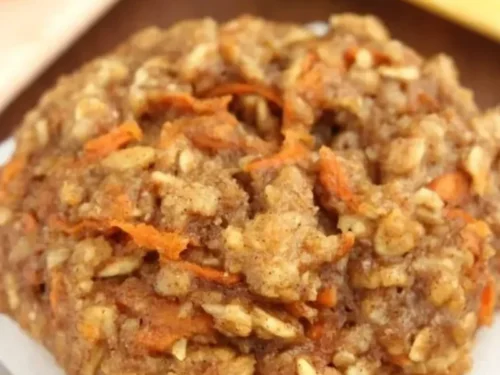 Delicious carrot cake oatmeal cookies on a plate, garnished with nuts and raisins.