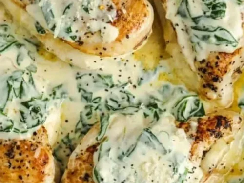 Cheese stuffed chicken breasts in creamy spinach sauce garnished with fresh herbs