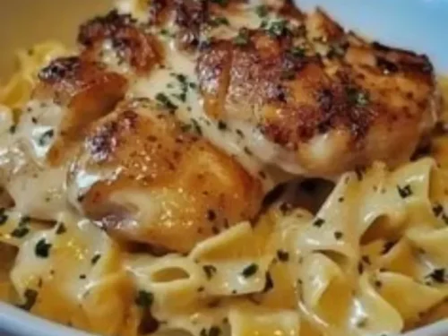 Plate of chicken served with buttered noodles