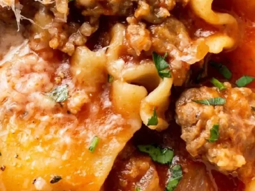 Bowl of healthy lasagna soup with garnishes on a wooden table