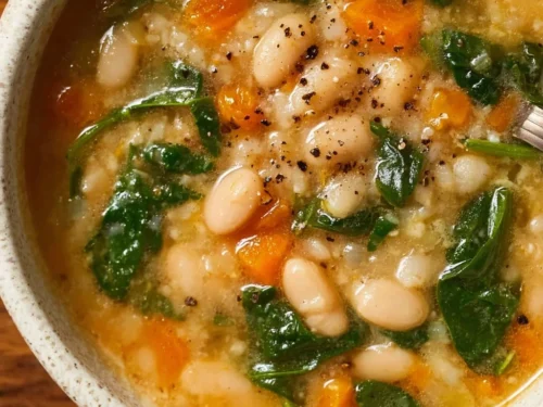Bowl of hearty low-calorie bean soup with white beans and fresh herbs