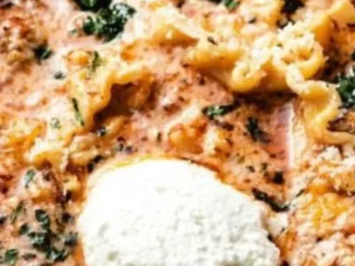 A bowl of Instant Pot Lasagna Soup topped with cheese and herbs.