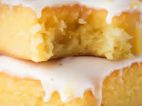Zesty lemon brownies topped with powdered sugar on a white plate
